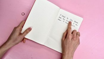 words written in a diary lying on a pink desk - personal branding london